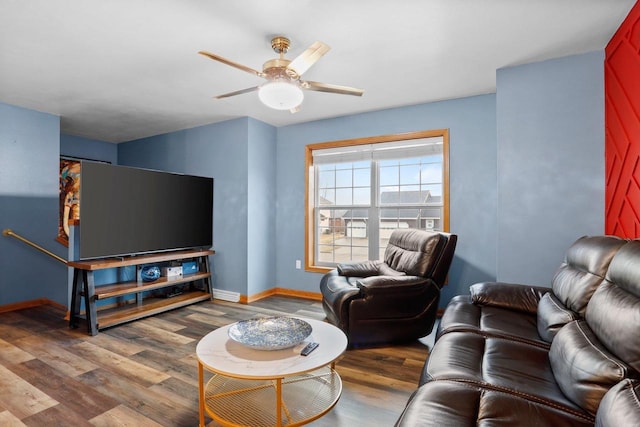 living area featuring baseboards, a ceiling fan, and wood finished floors