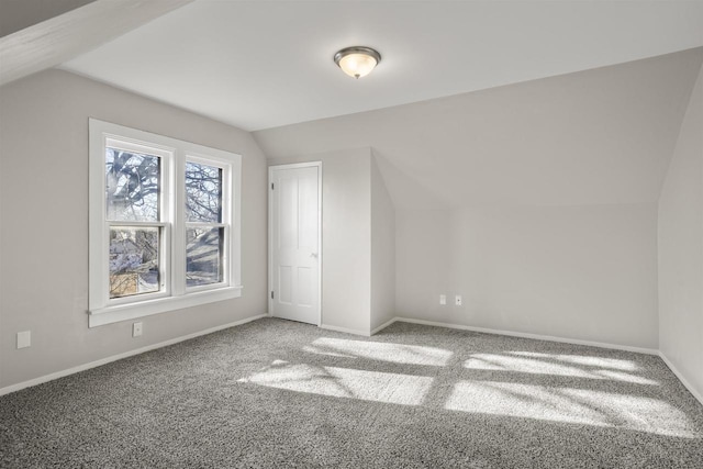 bonus room with vaulted ceiling and carpet