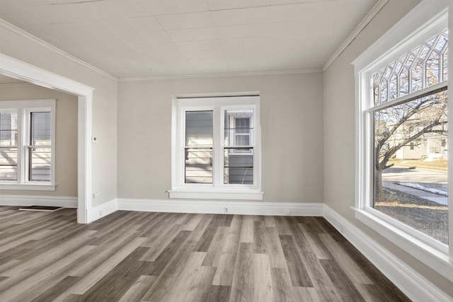 empty room featuring wood-type flooring and ornamental molding