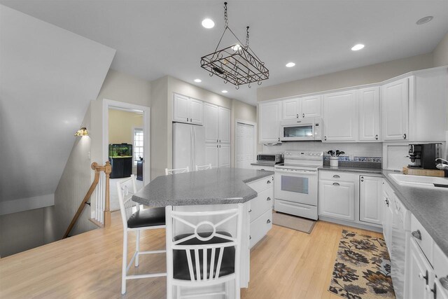 1809 Shady Point Dr, Verona, WI 53593 - kitchen with sink, white appliances, white cabinetry, a kitchen breakfast bar, and a kitchen island