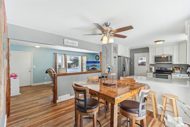 dining space featuring dark hardwood / wood-style flooring, sink, a wealth of natural light, and ceiling fan