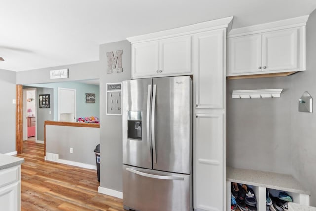 kitchen with white cabinetry, stainless steel fridge with ice dispenser, and light hardwood / wood-style flooring