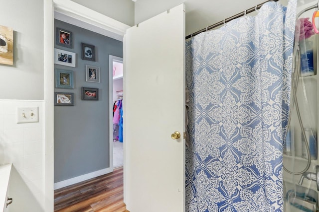 bathroom with hardwood / wood-style flooring and walk in shower