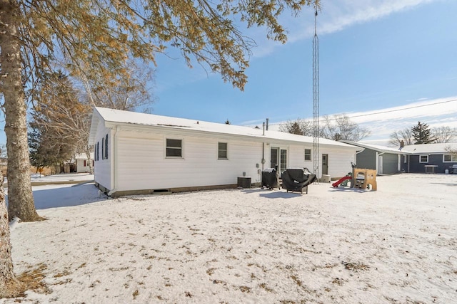 snow covered property with a garage and central air condition unit