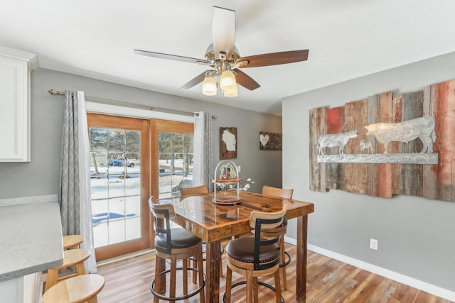 dining area with light hardwood / wood-style flooring and ceiling fan