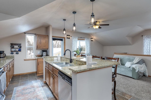 kitchen featuring a kitchen island with sink, a breakfast bar, decorative light fixtures, sink, and dishwasher