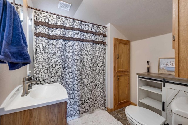 bathroom featuring tile patterned flooring, toilet, a textured ceiling, vaulted ceiling, and vanity