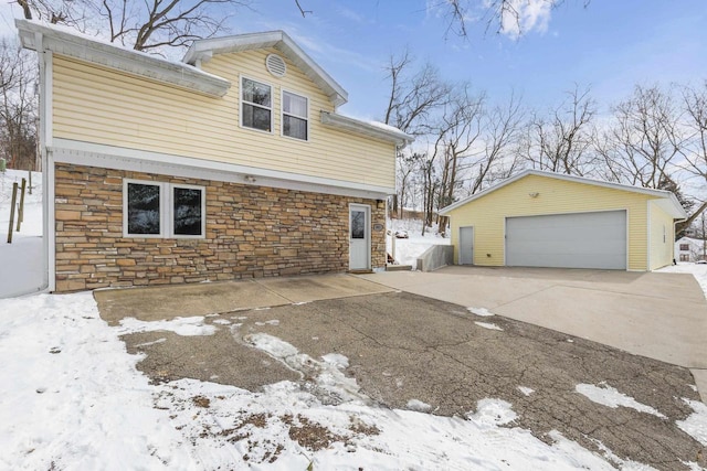 view of snow covered exterior with a garage and an outdoor structure