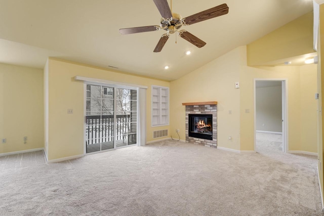 unfurnished living room featuring lofted ceiling, ceiling fan, light carpet, a brick fireplace, and built in shelves