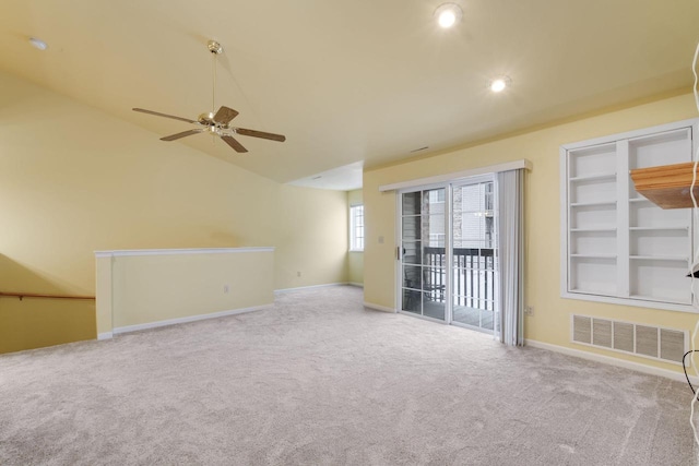 carpeted empty room with lofted ceiling, built in features, and ceiling fan