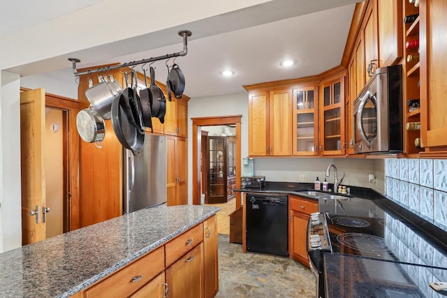 kitchen with dark stone countertops, sink, hanging light fixtures, and appliances with stainless steel finishes