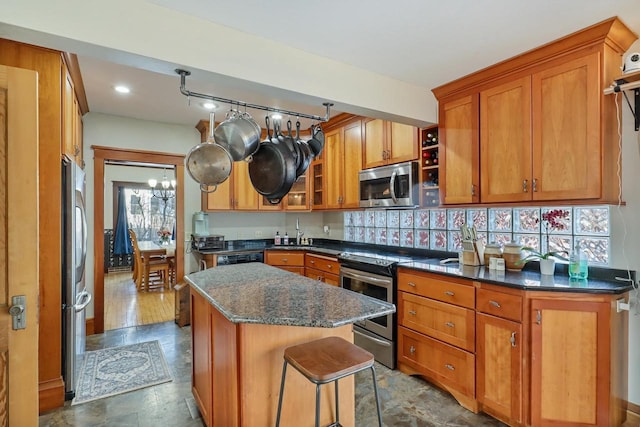 kitchen featuring sink, a kitchen breakfast bar, dark stone counters, a center island, and stainless steel appliances