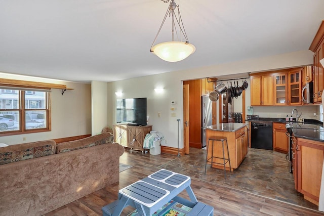 kitchen with a kitchen island, dark hardwood / wood-style floors, appliances with stainless steel finishes, a kitchen breakfast bar, and hanging light fixtures