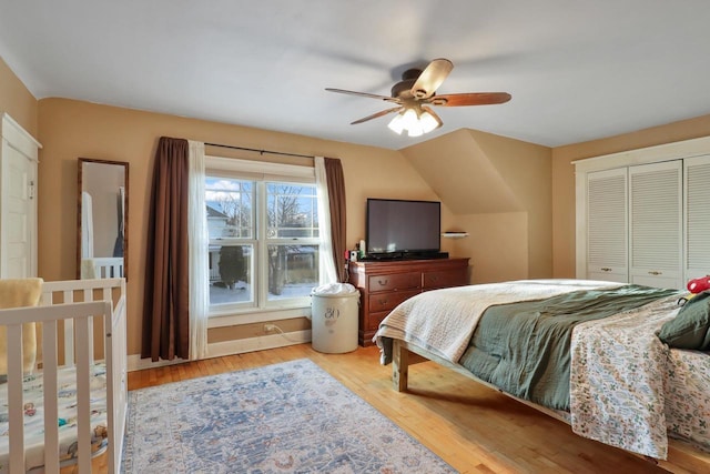 bedroom with vaulted ceiling, a closet, ceiling fan, and light wood-type flooring