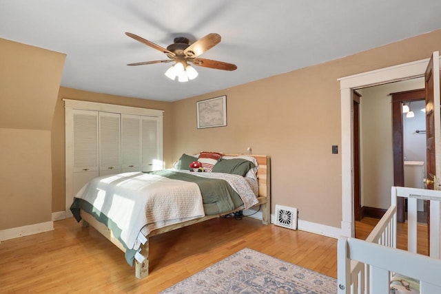 bedroom featuring ceiling fan, light hardwood / wood-style floors, and a closet