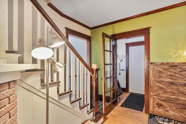 foyer with hardwood / wood-style floors and crown molding