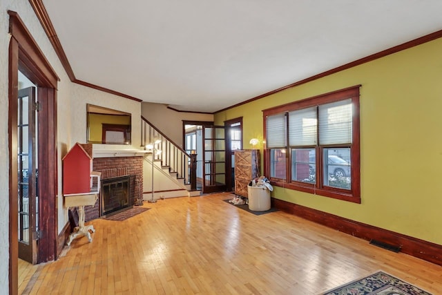 unfurnished living room with hardwood / wood-style flooring, crown molding, and a brick fireplace