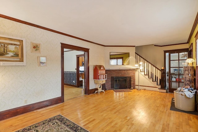 living room featuring a fireplace, ornamental molding, and wood-type flooring