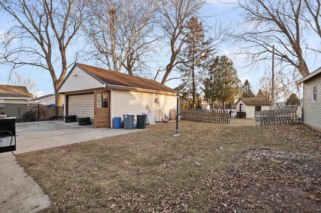 exterior space featuring a garage, an outbuilding, and a patio area