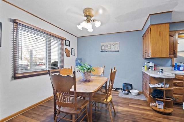 dining space with ornamental molding and dark hardwood / wood-style floors