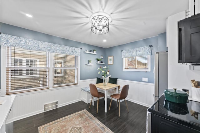 dining room with dark hardwood / wood-style floors and a chandelier