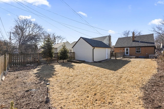 back of property featuring a yard, an outdoor structure, and central air condition unit