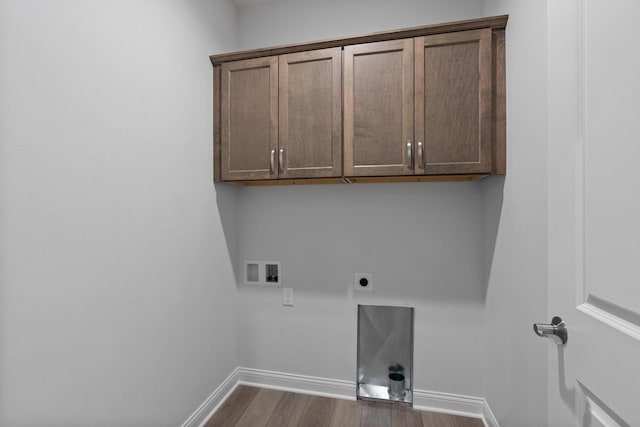 clothes washing area with cabinets, hardwood / wood-style floors, hookup for an electric dryer, and washer hookup