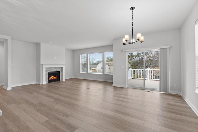 unfurnished living room with a chandelier and light hardwood / wood-style flooring