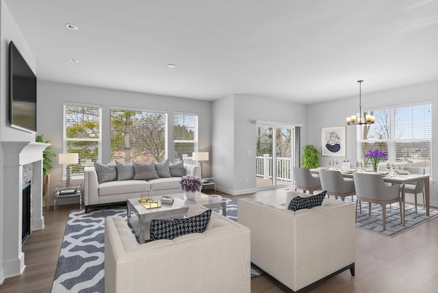 living room featuring an inviting chandelier, wood-type flooring, and plenty of natural light