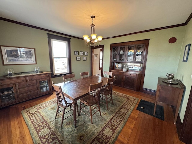 dining room with ornamental molding, a chandelier, and dark hardwood / wood-style flooring