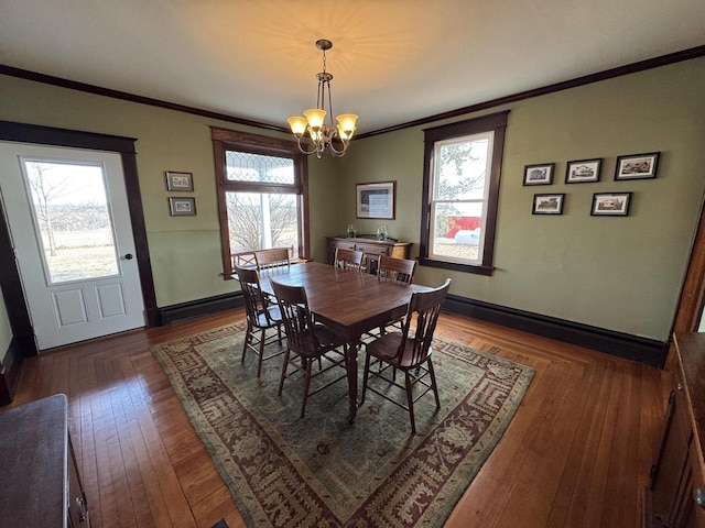 dining room featuring crown molding, a baseboard heating unit, dark wood-type flooring, and a notable chandelier