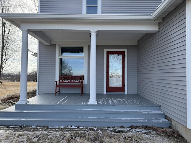 snow covered property entrance featuring a porch