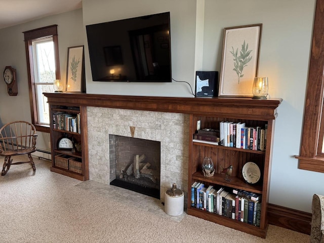 room details featuring a tile fireplace and carpet