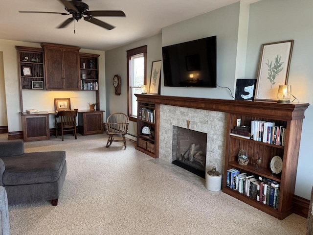 carpeted living room featuring a tile fireplace and ceiling fan