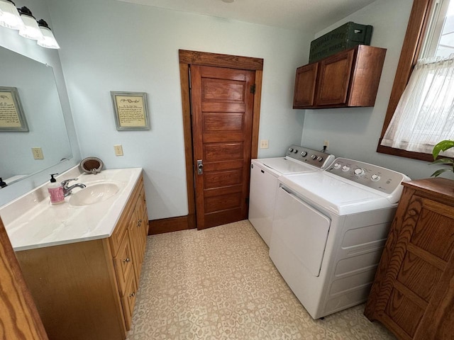 laundry area featuring cabinets, washing machine and clothes dryer, and sink