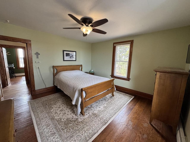 bedroom featuring dark hardwood / wood-style floors, ceiling fan, and baseboard heating