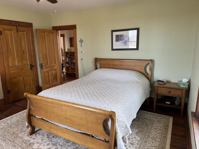 bedroom with dark hardwood / wood-style floors and ceiling fan