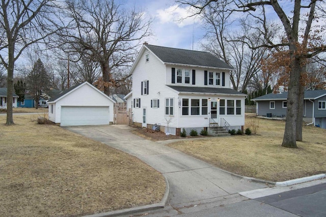 colonial home featuring a garage, an outdoor structure, and a front yard