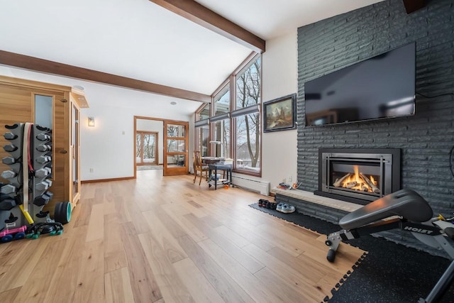 workout area with high vaulted ceiling, a fireplace, and light hardwood / wood-style flooring