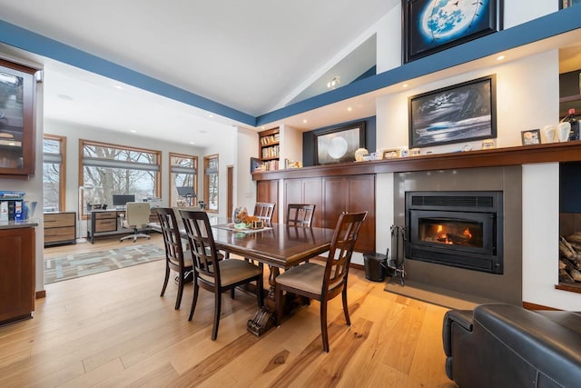 dining area featuring vaulted ceiling and light wood-type flooring