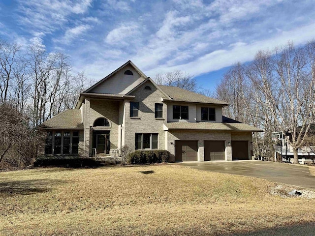 view of front of property featuring an attached garage, driveway, and a front lawn