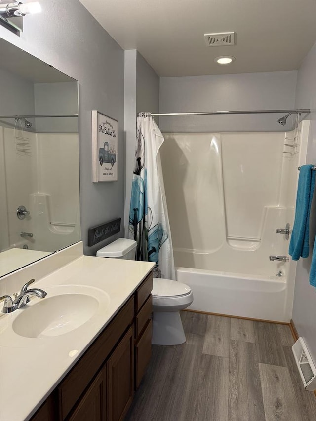 full bathroom featuring shower / bath combo with shower curtain, visible vents, toilet, and wood finished floors