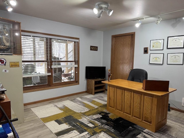 office area featuring track lighting, light wood-style flooring, and baseboards