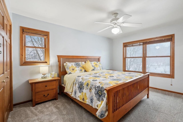 bedroom with light carpet, a closet, baseboards, and a ceiling fan