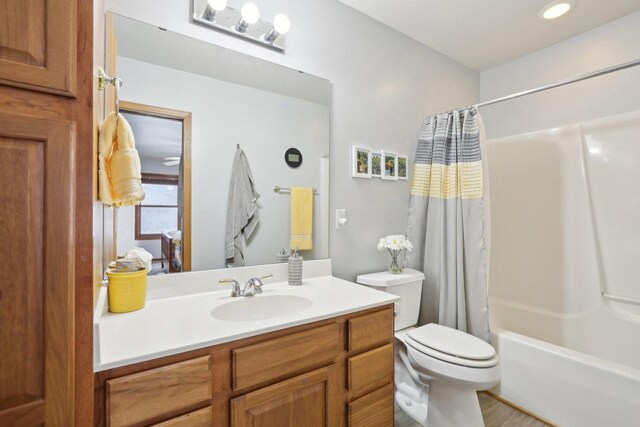 full bath with toilet, shower / bath combination with curtain, and vanity