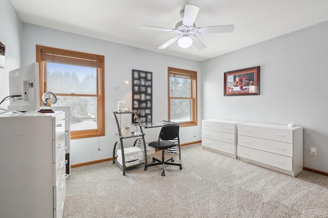 office area with baseboards, ceiling fan, and light colored carpet