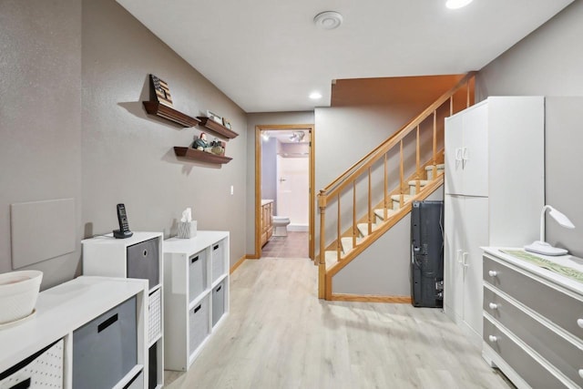 interior space featuring baseboards, stairway, recessed lighting, and light wood-style floors