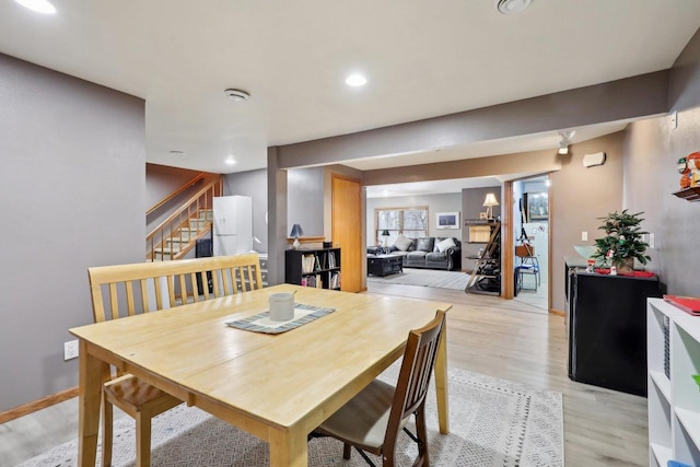 dining room with stairs, baseboards, light wood-style flooring, and recessed lighting