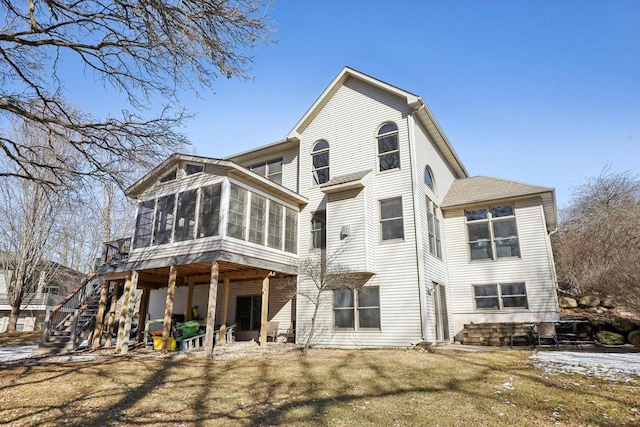 back of property featuring a sunroom and stairway