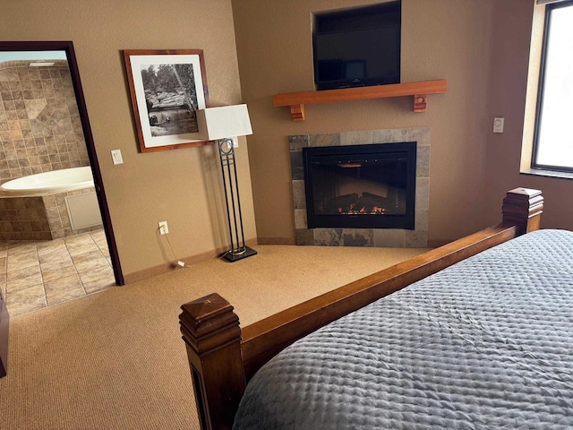 carpeted bedroom with a tiled fireplace and ensuite bathroom